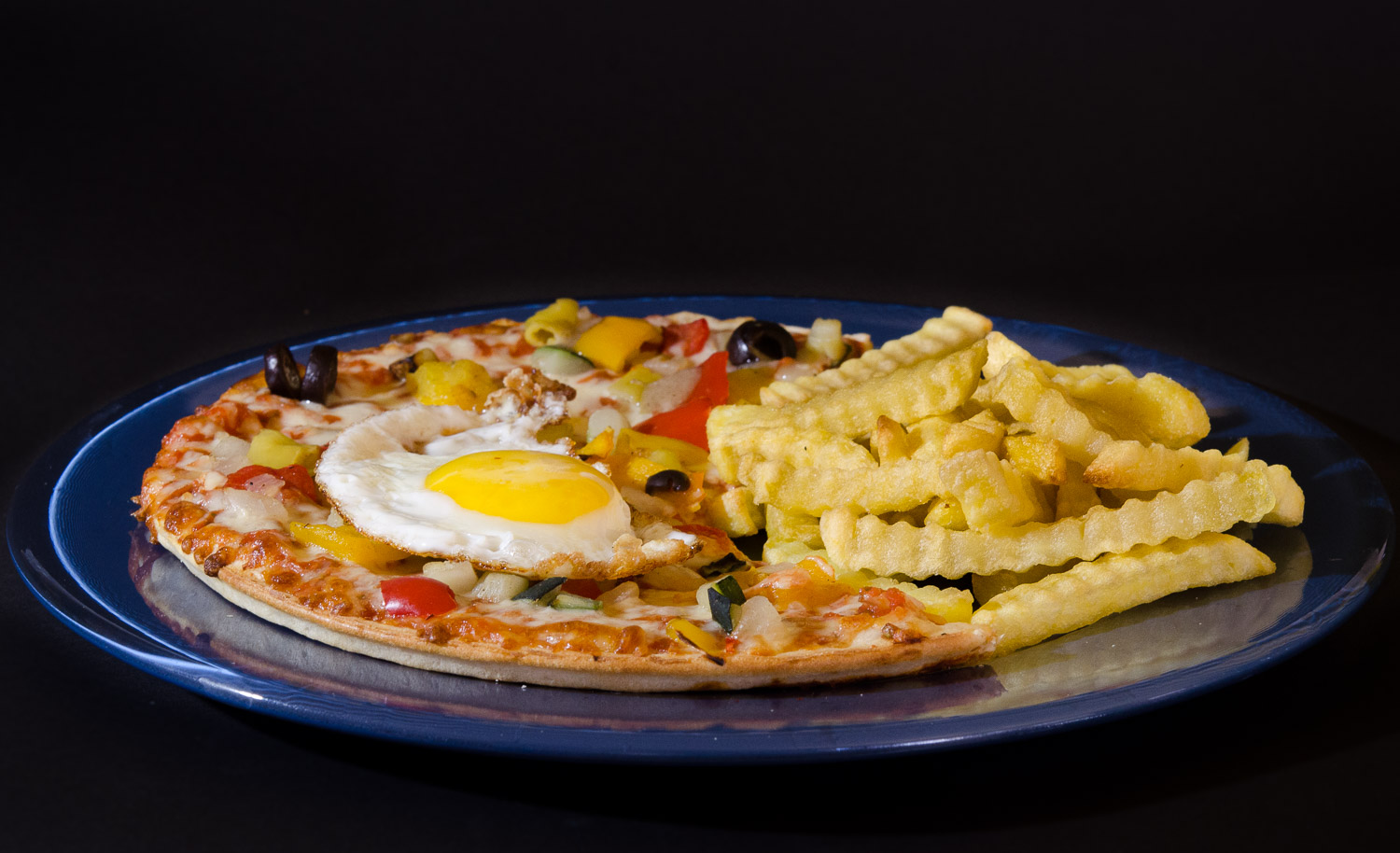 Pizza mit Pommes und Spiegelei